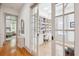 Inviting hallway featuring hardwood floors and a view into an office with built-in bookshelves at 22 Frogmore Rd, Mount Pleasant, SC 29464