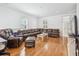 Bright living room featuring hardwood floors, an L-shaped leather sofa, and large windows with plantation shutters at 22 Frogmore Rd, Mount Pleasant, SC 29464