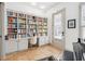 Home office boasts floor-to-ceiling bookshelves, built-in desk, and natural light at 22 Frogmore Rd, Mount Pleasant, SC 29464