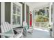 Inviting front porch with white rocking chairs and pops of color from throw pillows and foliage at 22 Frogmore Rd, Mount Pleasant, SC 29464