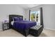 A modern bedroom displays a luxurious black bed frame, complementary bedding, and natural light at 259 Pine Shadow Dr, Goose Creek, SC 29445