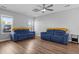 Inviting living room with a neutral color scheme, showcasing hardwood floors and comfortable blue seating beneath a modern fan at 259 Pine Shadow Dr, Goose Creek, SC 29445