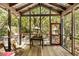 Charming screened porch with wooden floors overlooking a lush green landscape at 2808 Ion Ave, Sullivans Island, SC 29482