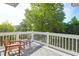 Deck area with a wooden chair and side table facing mature trees and blue skies at 281 Hawthorne St, Mount Pleasant, SC 29464