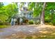 Charming home featuring a covered porch and landscaped yard with a mature tree and a gravel driveway at 281 Hawthorne St, Mount Pleasant, SC 29464