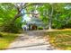 Charming home featuring a covered porch and landscaped yard with a mature tree and a gravel driveway at 281 Hawthorne St, Mount Pleasant, SC 29464