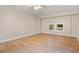 Spacious bedroom featuring hardwood floors, neutral walls, bright windows, and fan with light fixture at 298 Summerset Ln, Summerville, SC 29483