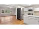 Open kitchen with stainless steel refrigerator, and view into the sunny living room at 298 Summerset Ln, Summerville, SC 29483