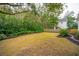 Spacious backyard with mature trees, manicured lawn, and a charming picket fence at 305 N Civitas St, Mount Pleasant, SC 29464