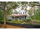 Side view of home with white siding, red roof, a screened in porch, landscaping and black picket fence at 305 N Civitas St, Mount Pleasant, SC 29464