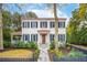 Charming two-story home with white siding, black shutters, a red roof and landscaped front yard at 305 N Civitas St, Mount Pleasant, SC 29464