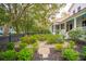 Beautifully landscaped garden with brick pathway, lush greenery, and a charming black fence at 305 N Civitas St, Mount Pleasant, SC 29464