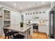 Bright kitchen with white cabinetry, granite countertops, island with seating, and stainless steel appliances at 305 N Civitas St, Mount Pleasant, SC 29464