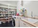 Well-organized laundry room with built-in shelving, modern washer/dryer, and sleek black floors at 305 N Civitas St, Mount Pleasant, SC 29464