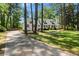 Charming white home with shuttered windows is complemented by a paved driveway and lush lawn at 309 Huntington Rd, Summerville, SC 29483