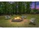 Inviting backyard fire pit with Adirondack chairs, surrounded by lush greenery and mature trees at 309 Huntington Rd, Summerville, SC 29483
