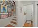 Hallway with wood floors leads to a stairwell decorated with custom art pieces at 309 Huntington Rd, Summerville, SC 29483