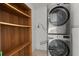 Updated laundry room featuring stacked washer/dryer and built in wooden shelving at 3308 Comsee Ln, Johns Island, SC 29455