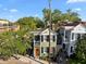 Charming two-story home with a light green exterior, complemented by lush landscaping and black shutters at 34 Pinckney St, Charleston, SC 29401