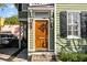 Inviting entryway with a wooden door, decorative sidelights, and brick steps at 34 Pinckney St, Charleston, SC 29401