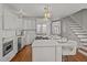 Stylish kitchen with island seating, gas range, stainless appliances, and hardwood floors at 34 Pinckney St, Charleston, SC 29401