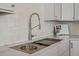 Modern kitchen sink featuring custom wood accents, a pull-down faucet, and white tile backsplash at 34 Pinckney St, Charleston, SC 29401
