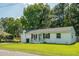 Charming one-story home featuring a white brick exterior, manicured lawn, and a quaint front porch at 407 Tammie Ave, Goose Creek, SC 29445