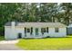 Charming one-story home featuring a white brick exterior, manicured lawn, and a quaint front porch at 407 Tammie Ave, Goose Creek, SC 29445