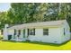 Charming one-story home featuring a white brick exterior, manicured lawn, and a quaint front porch at 407 Tammie Ave, Goose Creek, SC 29445