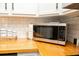 Updated kitchen with stainless microwave, butcher block countertops, and subway tile backsplash at 407 Tammie Ave, Goose Creek, SC 29445