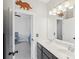 Well-lit bathroom with dual sinks, a large mirror, and an open doorway to an adjoining bedroom at 4082 Blackmoor St, Mount Pleasant, SC 29466
