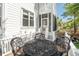 An outdoor patio with black metal table and chair set, with stairs leading to a screened porch at 4082 Blackmoor St, Mount Pleasant, SC 29466