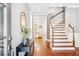 Welcoming foyer with hardwood floors, a curved staircase, and a decorative table with a mirror at 4082 Blackmoor St, Mount Pleasant, SC 29466