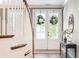 Inviting foyer with a white staircase, glass-paneled double doors adorned with wreaths, and a decorative table with a mirror at 4082 Blackmoor St, Mount Pleasant, SC 29466