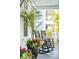 Inviting porch featuring rocking chairs, throw pillows, and colorful potted plants at 4082 Blackmoor St, Mount Pleasant, SC 29466