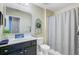 Bathroom features a shower with grey curtain, decorative wreath, vanity with black cabinets and white countertop at 409 Thoroughbred Dr, Moncks Corner, SC 29461
