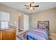 Neutral-colored bedroom with ceiling fan, window, dresser, and bed with colorful patterned comforter and rug at 409 Thoroughbred Dr, Moncks Corner, SC 29461