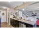Open kitchen area features a stainless steel sink, dark cabinets and bar overlooking living area at 409 Thoroughbred Dr, Moncks Corner, SC 29461