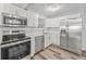Bright kitchen features stainless steel appliances, white cabinets, quartz countertops, and stylish lighting at 415 Parkdale Dr # 2B, Charleston, SC 29414