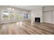 Open-concept living area featuring a fireplace, hardwood floors, and multiple windows for natural light at 4996 Song Sparrow Way, Summerville, SC 29483