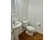 Traditional half bath features a pedestal sink, toilet, and wood floors at 5226 Fernland Way, North Charleston, SC 29420