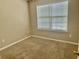 Neutral bedroom features a large window that allows for ample natural light and plush carpeting at 5226 Fernland Way, North Charleston, SC 29420