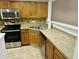 Well-equipped kitchen with stainless steel appliances, wood cabinets, and tile countertops at 5226 Fernland Way, North Charleston, SC 29420