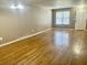Bright living room features hardwood floors, a neutral paint color, and a large window at 5226 Fernland Way, North Charleston, SC 29420