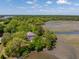 Aerial view of a traditional home surrounded by forest and a marsh landscape at 5569 Frisco Ln, Johns Island, SC 29455