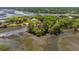 Picturesque aerial view of a waterfront property with a home surrounded by trees, near a tranquil river and marshland at 5569 Frisco Ln, Johns Island, SC 29455