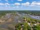 Breathtaking aerial view of marshlands and winding waterways, showcasing lush green landscapes against a cloudy blue sky at 5569 Frisco Ln, Johns Island, SC 29455