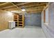 Unfinished basement area featuring a small white utility sink, wall shelving, and concrete flooring at 5569 Frisco Ln, Johns Island, SC 29455