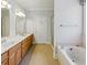 Well-lit bathroom with a double sink vanity, a large soaking tub, and a separate glass-enclosed shower at 5569 Frisco Ln, Johns Island, SC 29455