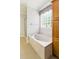 Serene bathroom featuring a soaking tub with jets, a glass block window, and a separate glass-enclosed shower at 5569 Frisco Ln, Johns Island, SC 29455